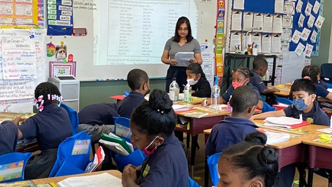 Students learning as a group at tables.