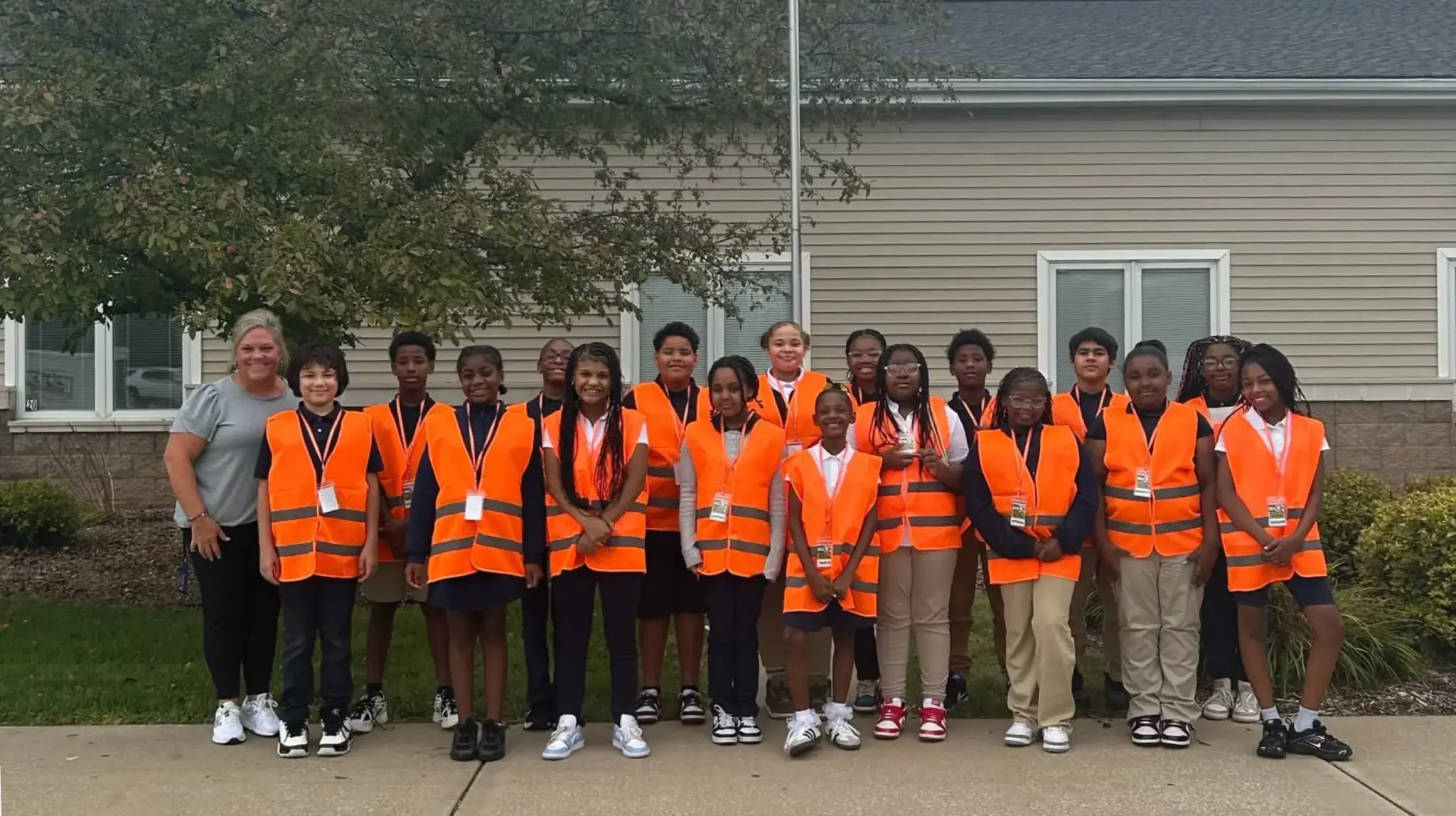 a group of children in orange vests