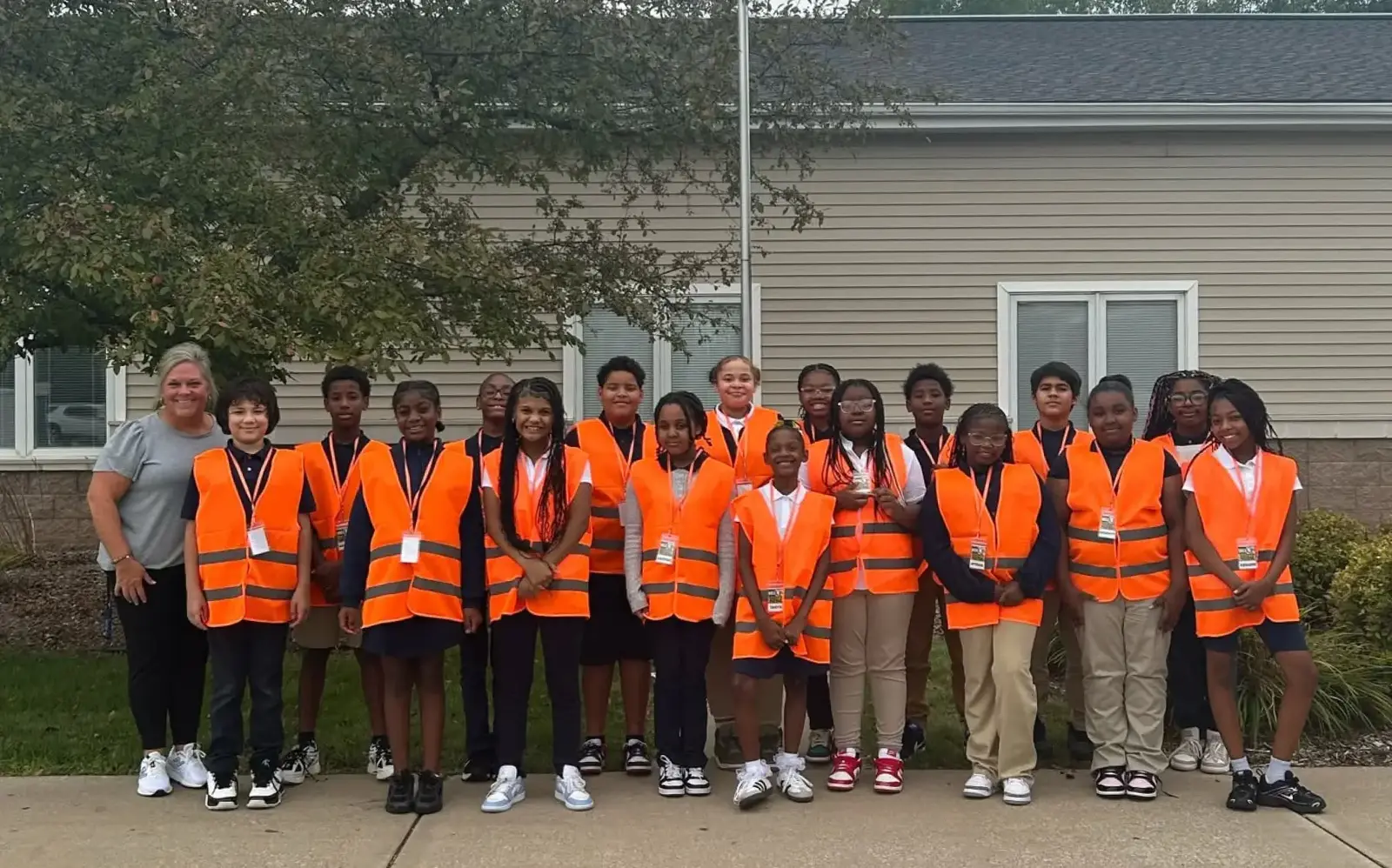 a group of children in orange vests