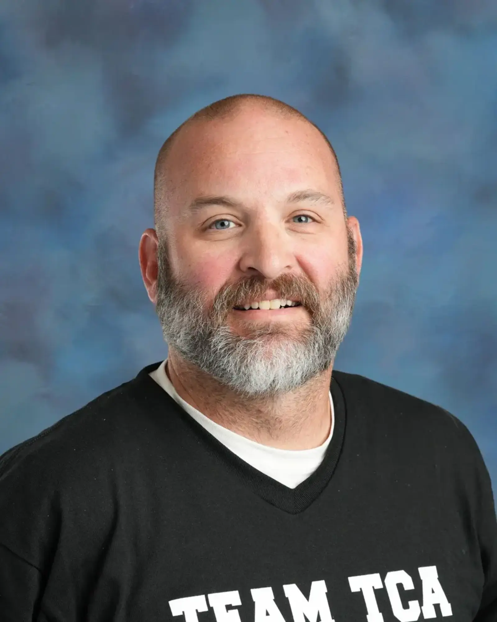 a man with a beard smiling
