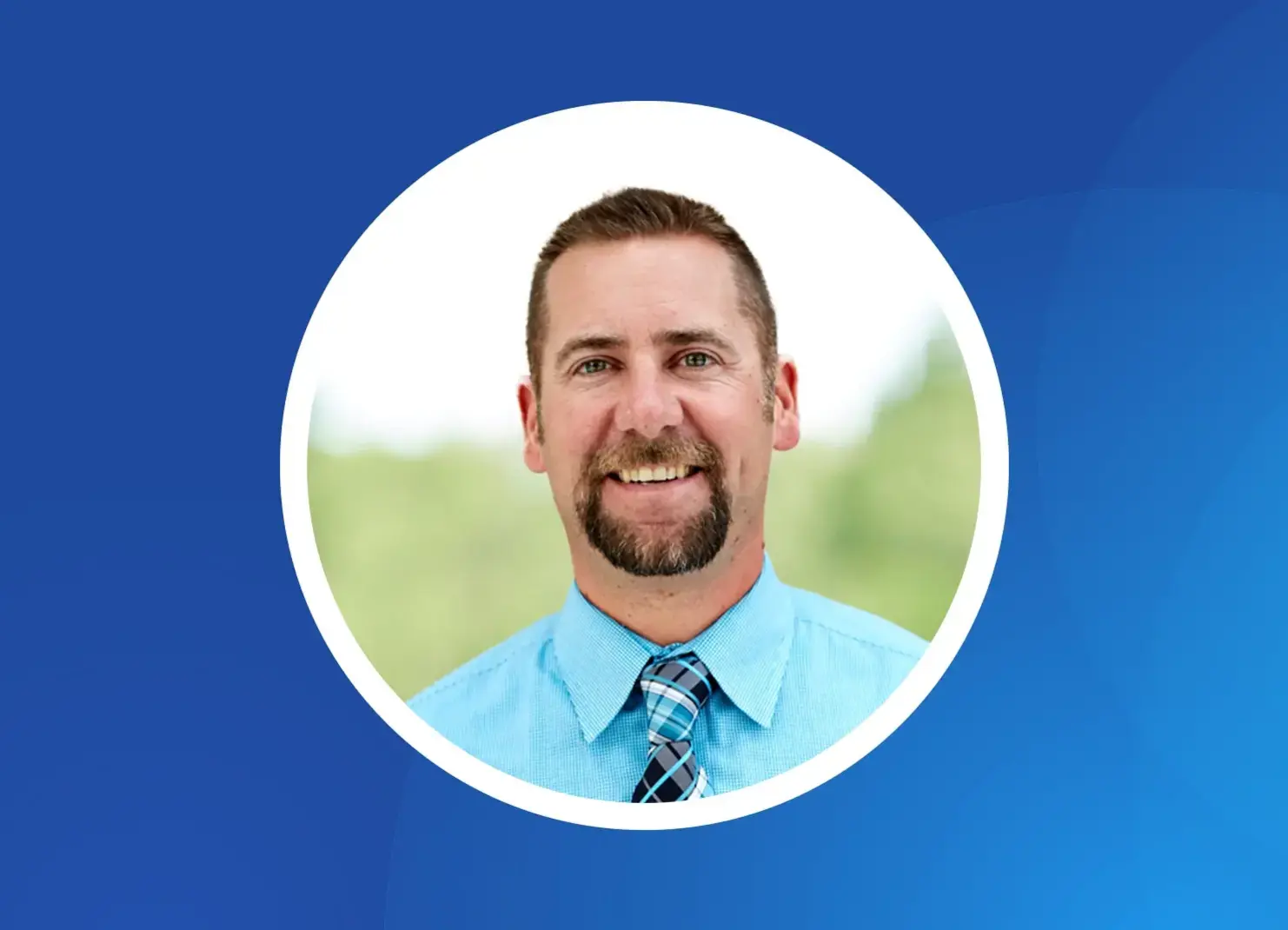 a man with a beard and mustache wearing a blue shirt and tie