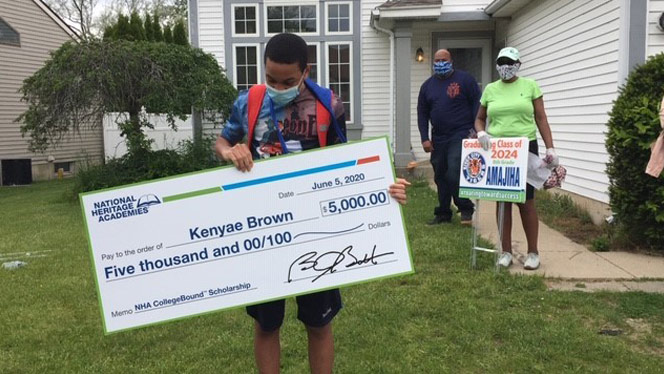 Kenyae Brown holding large $5,000 check.