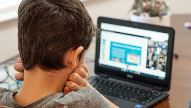 A boy looking at a computer screen.