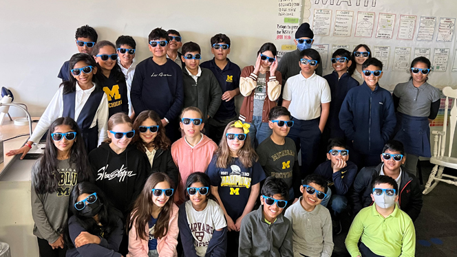 Students wearing sunglasses smiling.