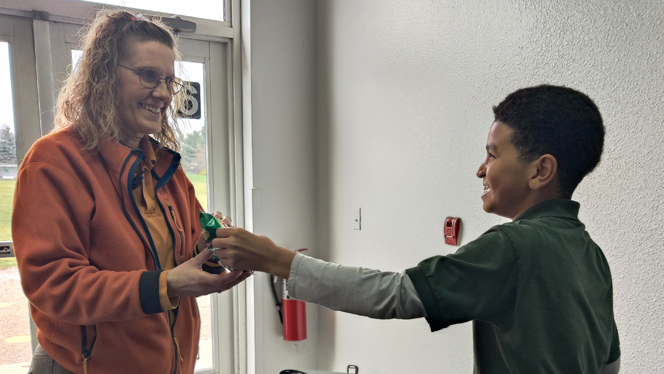 Student giving staff member their purchased item.