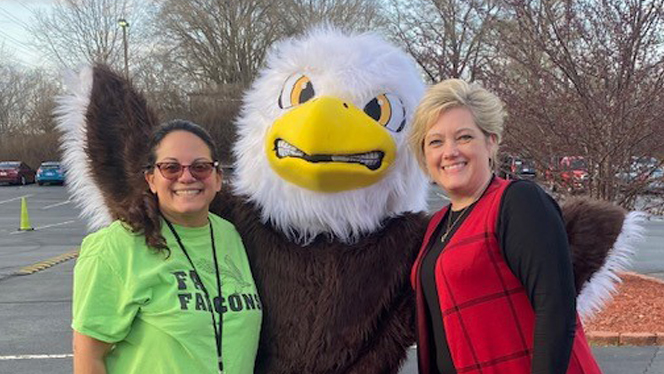 Wendy Barajas standing with an Eagle mascot.