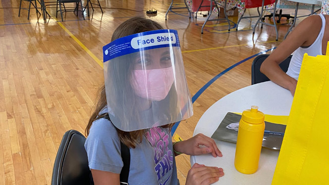 A student wearing a face mask and face shield.