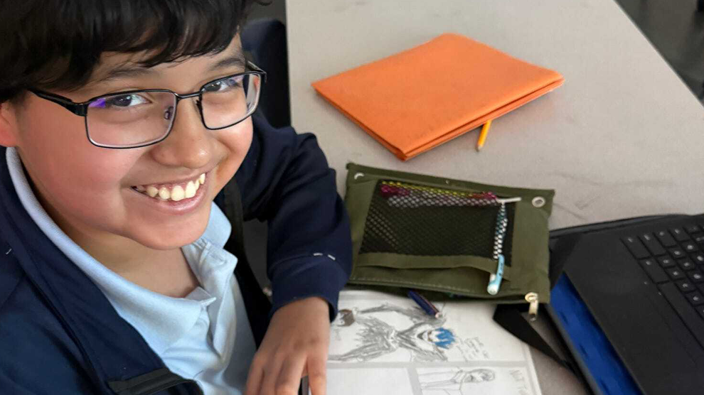 Student smiling at desk