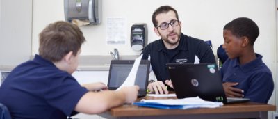 Teacher helps students complete work