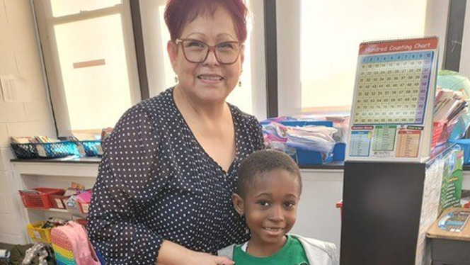 Gonzalez smiling with student.