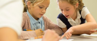 K-8 School in Commerce City: Two students working on class work together.