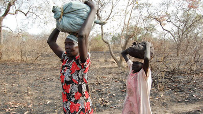 South Sudanese people carrying objects on their heads.