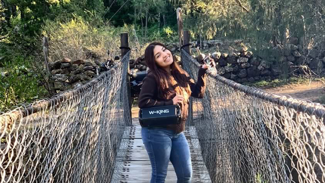 Brianna Arvizu smiling on a rope bridge.