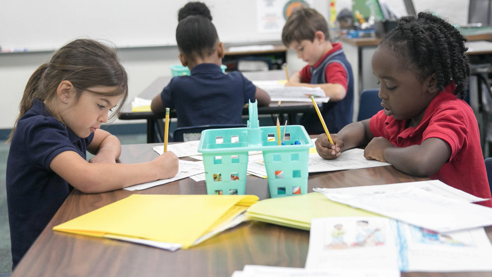 Two students smiling in front of their classroom lockers