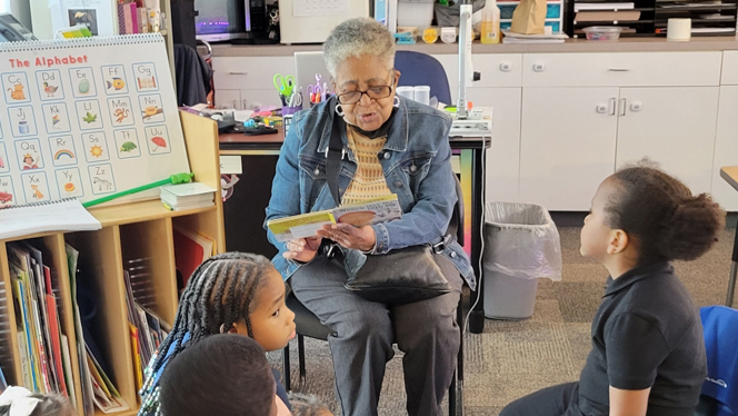 grandparent reading a book to scholars.