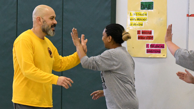 Principal Hector Ulloa high fiving his staff teammates during the game.