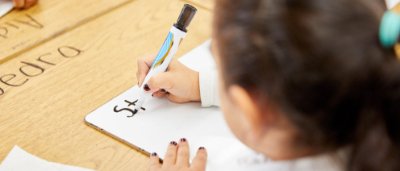 K-8 School in Dayton: Student writing on white board.