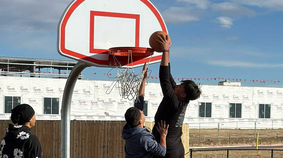 Two students playing basketball outside