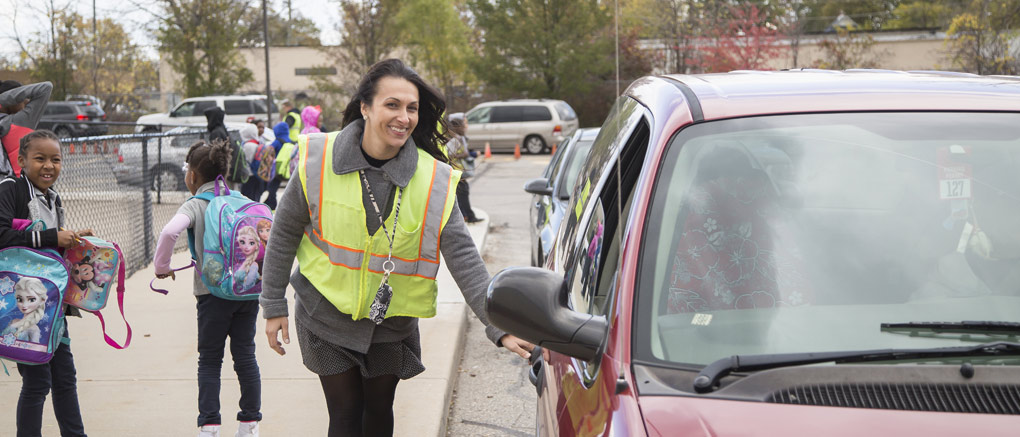 Helping student into car