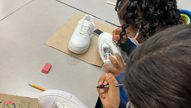 Student painting a pair of shoes.