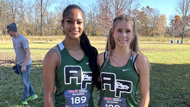Two students smiling in front of their classroom lockers