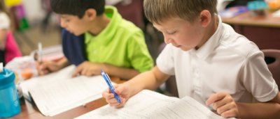 K-8 School in Canton MI: Students doing activities in workbook at their desk.