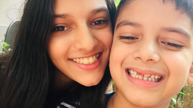 Anya Joshi smiling with her brother.