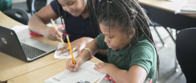 Two students completing work in classroom