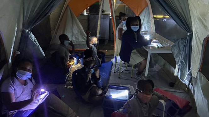 Students reading in a tent