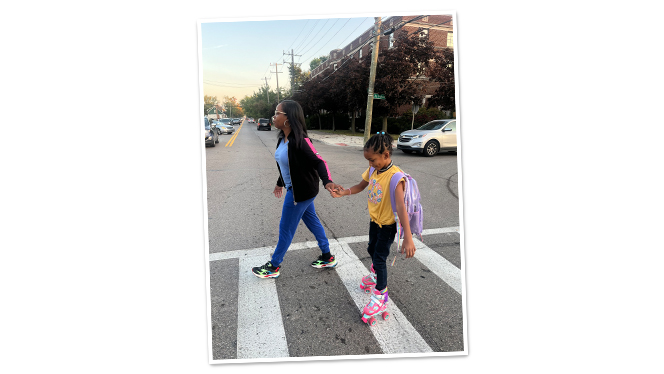 Mom walking with daughter on roller skates.