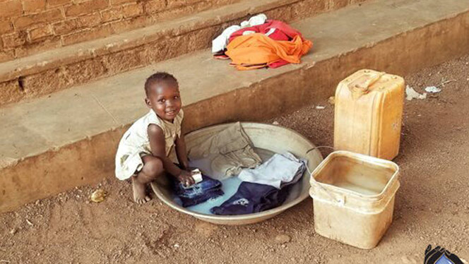 South Sudanese child washing their clothes.