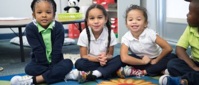 Three students smiling in classroom