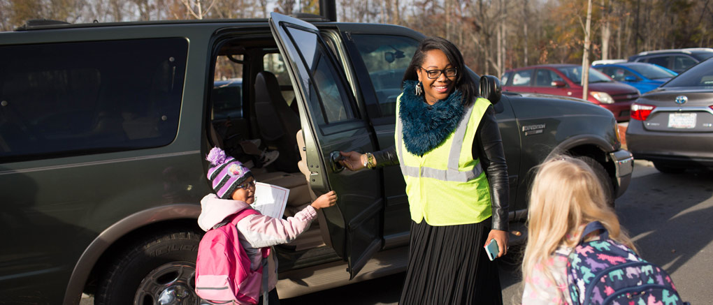 Teacher assisting arriving students