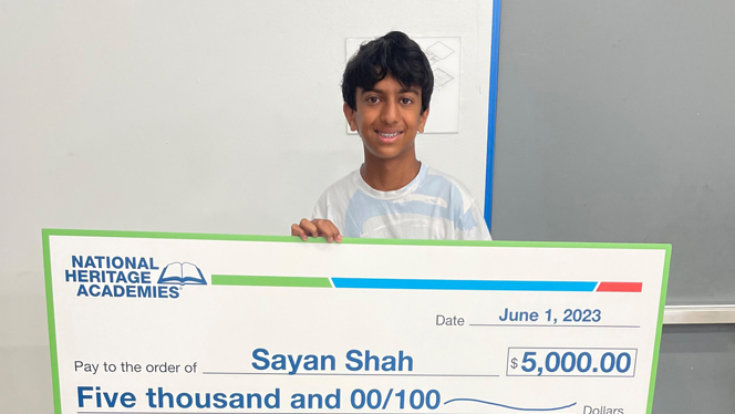 Sayan Shah holding his scholarship.