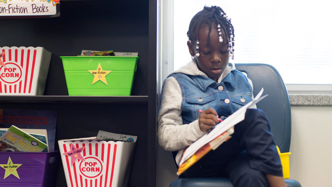 Matthews student writing on paper