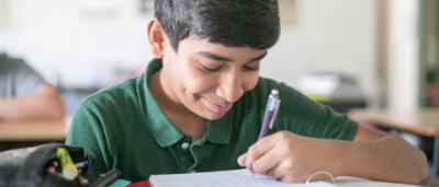 K-8 School in Canton: Student writing in notebook.