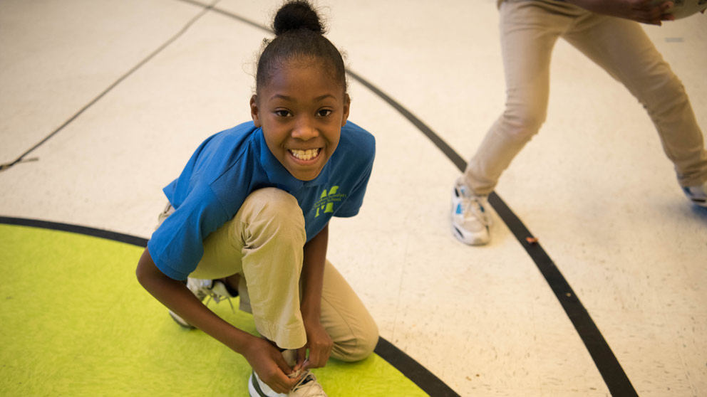 Two students smiling in front of their classroom lockers