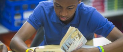 Student reading a book in classroom
