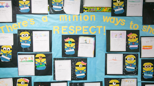 Two students smiling in front of their classroom lockers