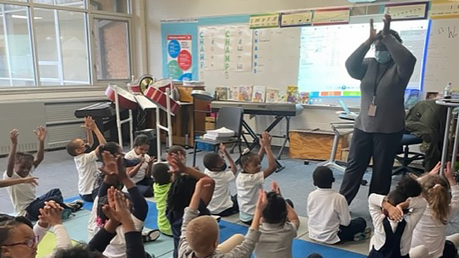 Teacher clapping with students.