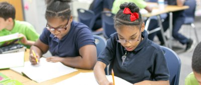 Burton Glen Charter Academy, Y5-8 School in Burton, MI: students sitting at a desk working on classwork.