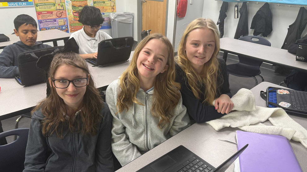 Students sitting at table smiling