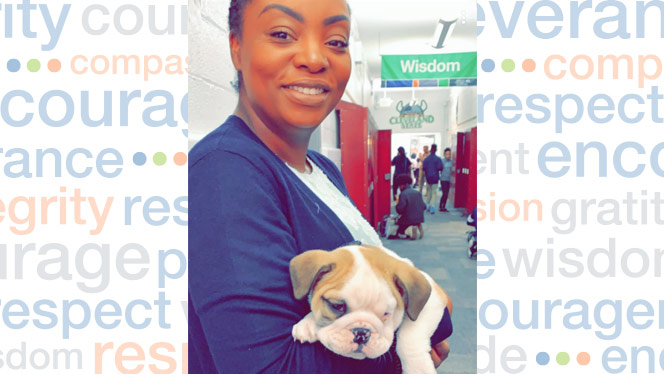 Charlena Hunt holding a puppy and smiling.