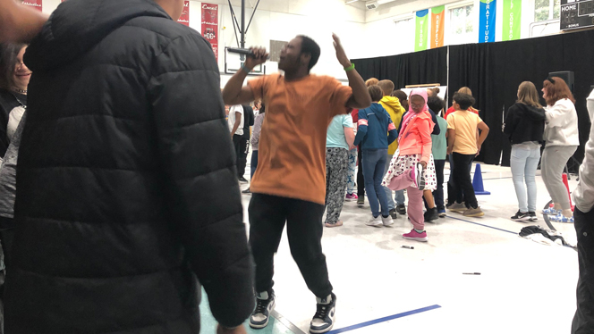Singer leading students in dance.