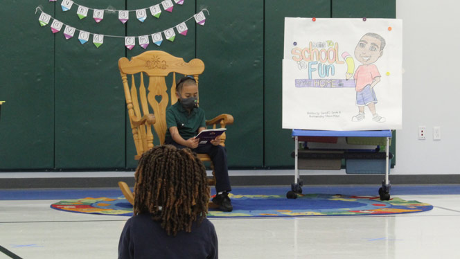 East Arbor student Davis Smith reads his book to students