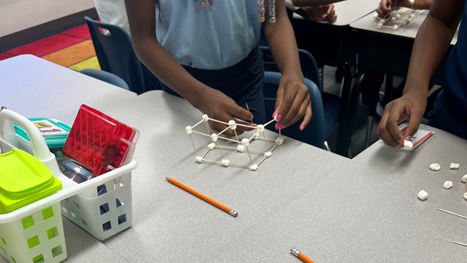 Students building wide structure.
