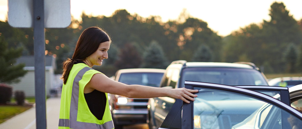 Teacher helping student into car