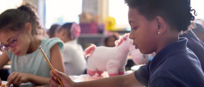 K-8 School in Dayton: Student holding pencil at desk.