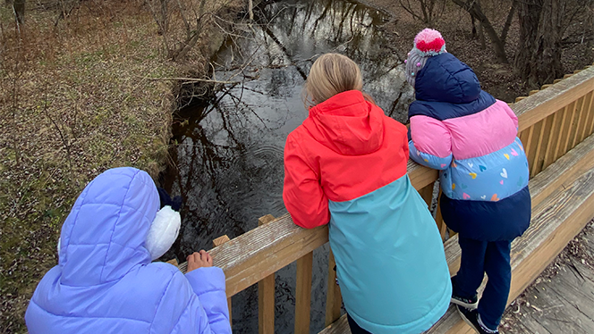 Students overlooking creek.