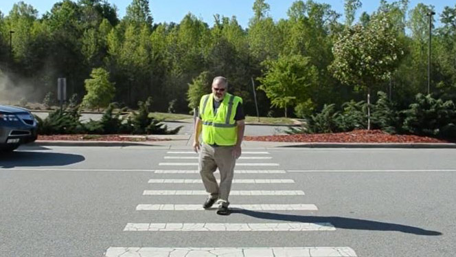 Swofford crossing the street in a safety vest.